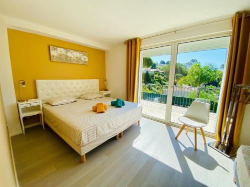 une chambre avec un lit et une grande fenêtre dans l'établissement Villa Doisy, à La Colle-sur-Loup