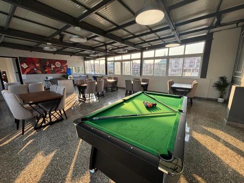 a pool table in a room with tables and chairs at Housr 36 Studio Rooms Bangalore Near Leela Palace in Bengaluru