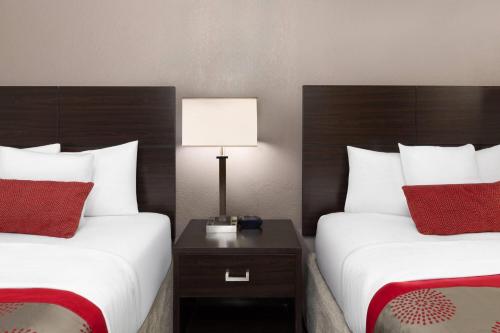 a hotel room with two beds and a table with a lamp at Ramada by Wyndham El Paso in El Paso