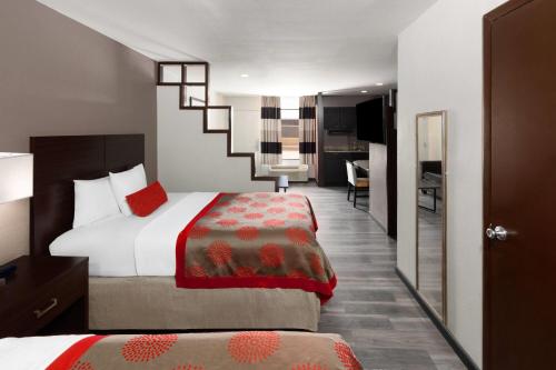 a hotel room with a bed and a living room at Ramada by Wyndham El Paso in El Paso