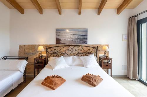 a bedroom with a white bed with two brown mitts on it at Agroturisme Es Racó De Maria in Maria de la Salut