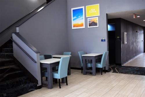 a dining room with two tables and blue chairs at Days Inn by Wyndham Montgomery in Montgomery
