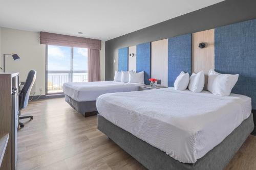 a hotel room with two beds and a balcony at The Jordan Hotel Ramada by Wyndham in Jordan