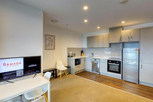a large kitchen with a desk and a counter top at Ramada Suites by Wyndham Queenstown Remarkables Park in Queenstown