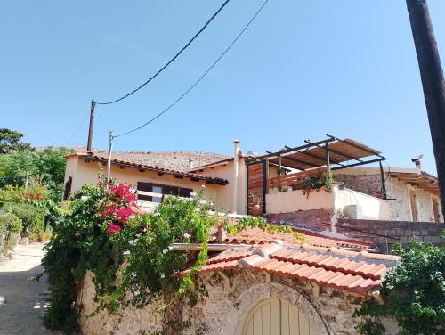 a house with a gate and flowers on it at Agrotourism Traditional Houses in Apóstoloi