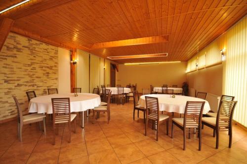 a dining room with white tables and chairs at Penzión Stefani in Smižany