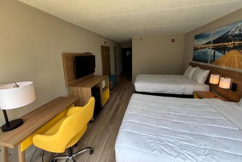 a hotel room with two beds and a television at Days Hotel by Wyndham Williamsburg I-64 in Williamsburg