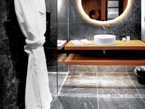 a bathroom with a sink and a mirror at Swissôtel Damian Jasna in Demanovska Dolina