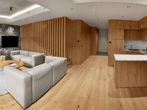 a living room with a couch and a kitchen at Swissôtel Damian Jasna in Demanovska Dolina