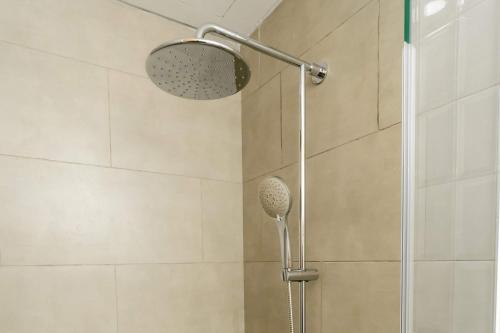 a shower with a shower head in a bathroom at Howard Johnson By Wyndham Tangerang in Tangerang