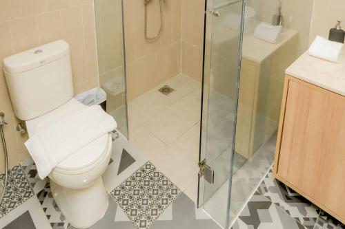 a bathroom with a toilet and a glass shower at Howard Johnson By Wyndham Tangerang in Tangerang