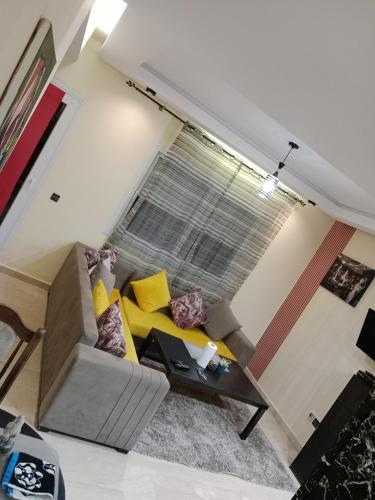 Una sala de estar con un sofá y una ventana. en Résidence journalière chic Casablanca, en Casablanca