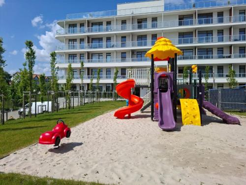 a playground in the sand in front of a building at Apartament Happy 46 Hampton z klimatyzacją - tuż przy plaży!!! in Sianozety