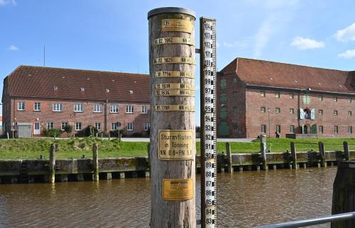 a pole with signs on it next to a body of water at Nordfriesisches Haus in Tönning