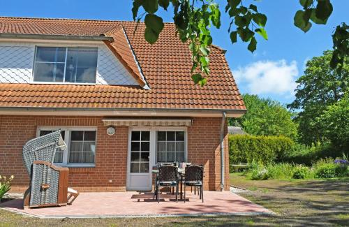a house with two chairs and a table on a patio at schöne 3-Raum-Ferienwohnung direkt im Nationalpark in Ummanz