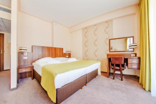 sypialnia z łóżkiem, biurkiem i lustrem w obiekcie Apartamenty Sun & Snow w Verano w Kołobrzegu