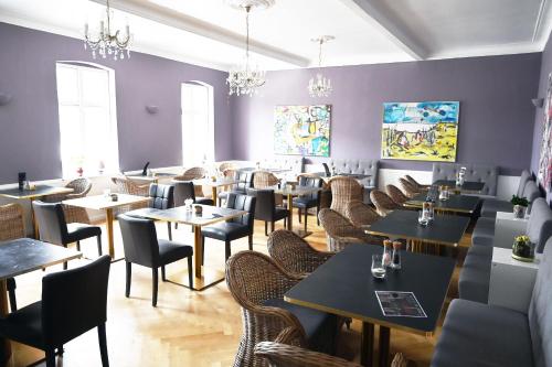 a restaurant with tables and chairs and purple walls at Nordfriesisches Haus in Tönning