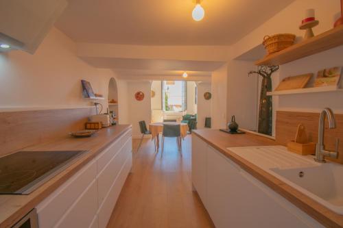 une cuisine avec des armoires blanches et un comptoir dans l'établissement Le Gazan, belle vue, centre historique, 60m2, 2 ch, à Grasse