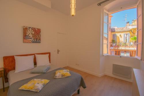 une chambre avec deux lits et une grande fenêtre dans l'établissement Le Gazan, belle vue, centre historique, 60m2, 2 ch, à Grasse