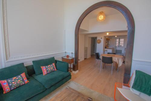 un salon avec un canapé vert et une table dans l'établissement Le Gazan, belle vue, centre historique, 60m2, 2 ch, à Grasse