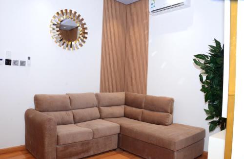 a brown couch in a living room with a mirror at فندق اليقنت الفندقية in Najran