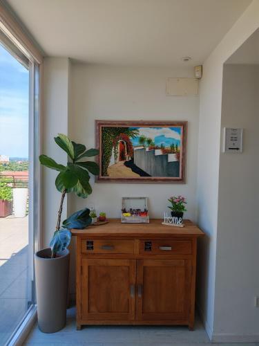 a wooden cabinet in a room with a potted plant at Nuova Opera Rooms in Verona
