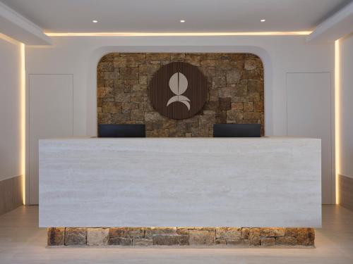 a reception desk in a lobby with a brick wall at Iria Blue Mykonos in Platis Yialos Mykonos