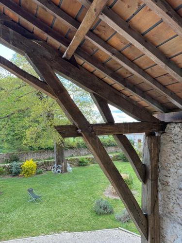 a wooden pergola in a garden with a lawn at Le Poutic gîte et maison d'hôtes in Créon-dʼArmagnac