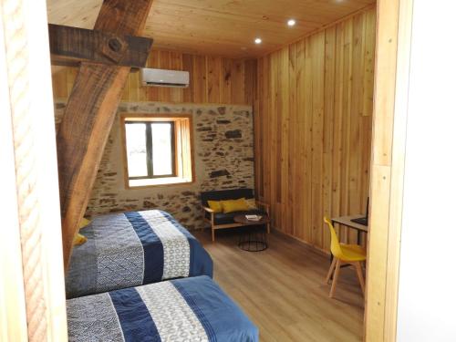 a bedroom with a bed and a desk and a chair at Chambre d'hôtes de charme Pierres anciennes, confort et nature in Savignac-Lédrier