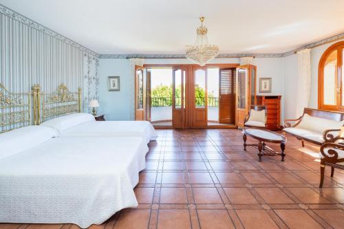 a bedroom with two beds and a chandelier at Maravilloso chalet con piscina en Baza in Baza