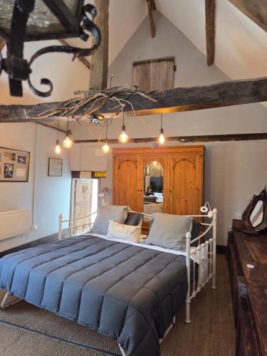 a bedroom with a large bed with blue sheets at Les Petits Champs in Buais