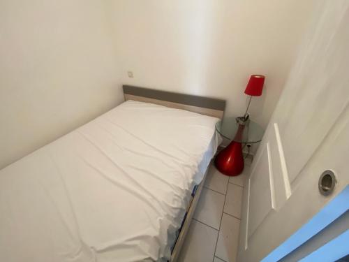 - une petite chambre avec un lit et une lampe rouge dans l'établissement Studio bord de mer Max 4 personnes, à Saint-Hilaire-de-Riez