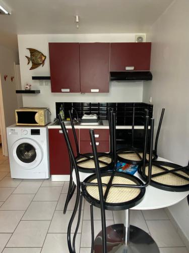 une cuisine avec une table et des chaises ainsi qu'un lave-linge. dans l'établissement Studio bord de mer Max 4 personnes, à Saint-Hilaire-de-Riez