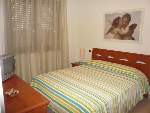 una camera da letto con un letto e una televisione di Aquarius a Montesilvano Marina