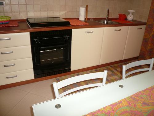 una cucina con forno nero e lavandino di Aquarius a Montesilvano Marina
