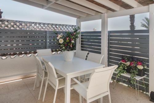 a white table and chairs on a balcony with flowers at Botanical Art House by Staycom in Paphos City