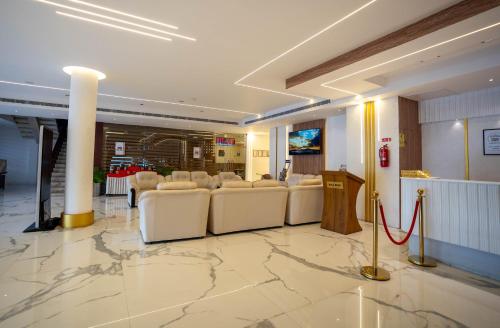 a lobby with white leather chairs and a podium at Casino Hotels Ltd in Trichūr