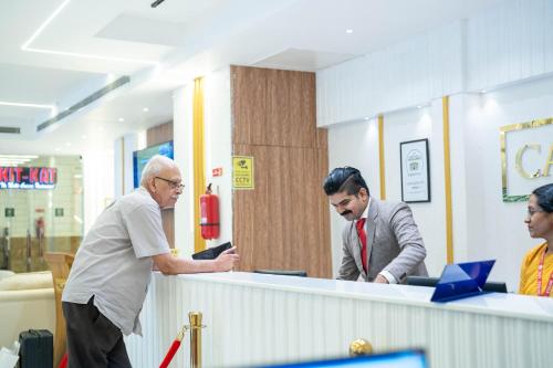 two men standing at a reception counter in a store at Casino Hotels Ltd in Trichūr