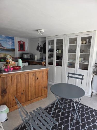 une cuisine avec une table et un comptoir dans l'établissement Les Petits Champs, à Buais