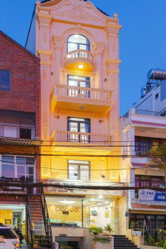 a yellow building with a balcony on the side of it at AN Boutique Hotel in Da Lat