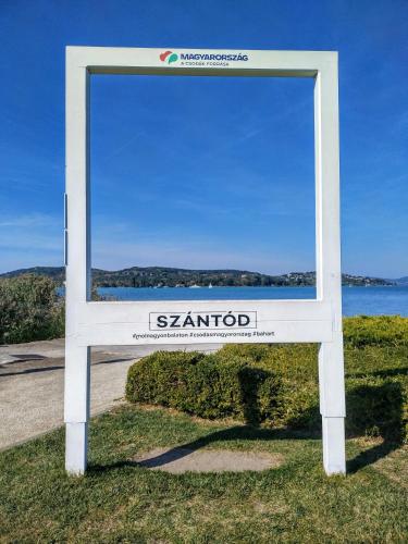 a sign for the santodm sign in the grass at Apartman a Déliparton in Szántód