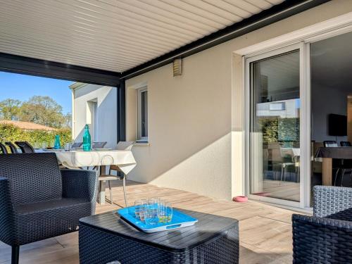 eine Terrasse mit einem Tisch, Stühlen und einem Tisch in der Unterkunft Les Merisiers - Maison moderne avec jardin in Pornic