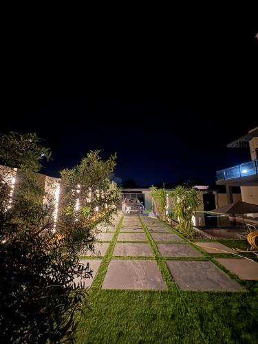 a garden at night with lights on the grass at La Demeure du Bonheur in Hammamet Sud