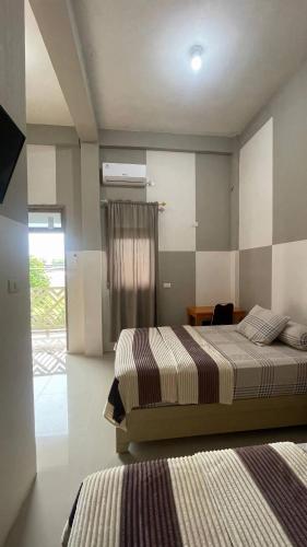 a bedroom with two beds and a window at Homestay Yaa Syafi in Bireun