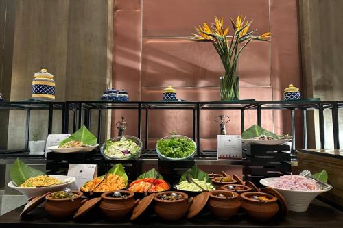 a buffet with bowls of different types of food at Vivanta Bhubaneswar DN Square in Bhubaneshwar