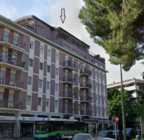 a bus is parked in front of a pink building at Nuova Opera Rooms in Verona