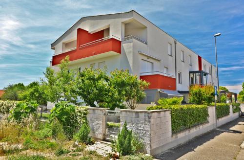 a white and red building with bushes in front of it at SOFIA house with apartment in Umag