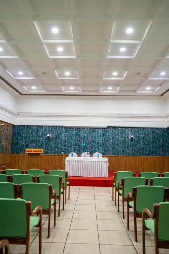 a conference room with green chairs and a table at Casino Hotels Ltd in Trichūr