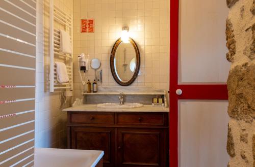 a bathroom with a sink and a mirror at Château Hôtel Du Colombier in Saint Malo