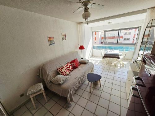 un salon avec un canapé et une grande fenêtre dans l'établissement ARGELES PLAGE STUDIO PISCINE PARK PRIVATIF dans RES SECURISEE, à Argelès-sur-Mer